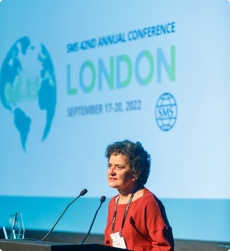 Woman Speaking at London conference SMS Member speaking on stage during the SMS 42nd annual conference