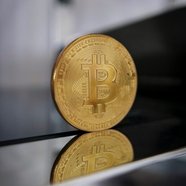 a gold bitcoin sitting on top of a table