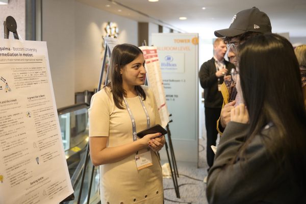 SMS PhD student interacting in front of poster presentation.