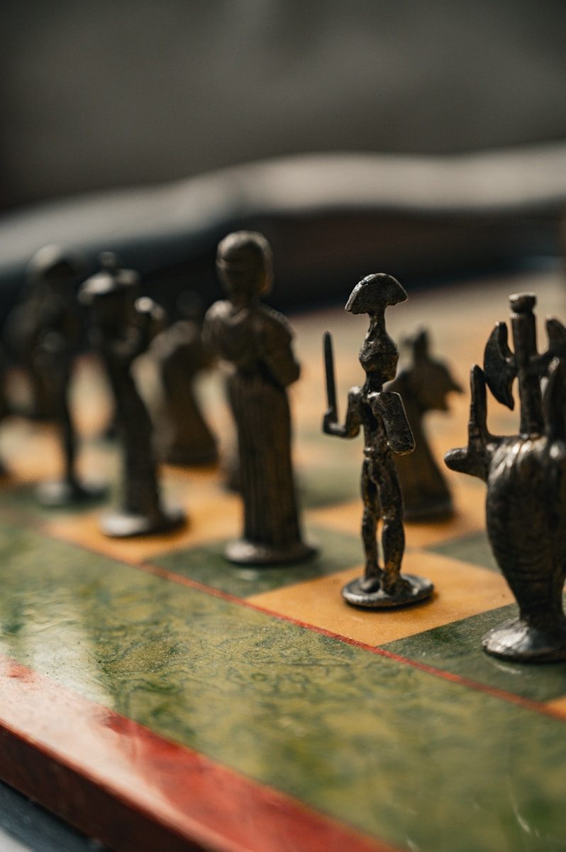 Close-up of antique metal chess pieces on a chessboard